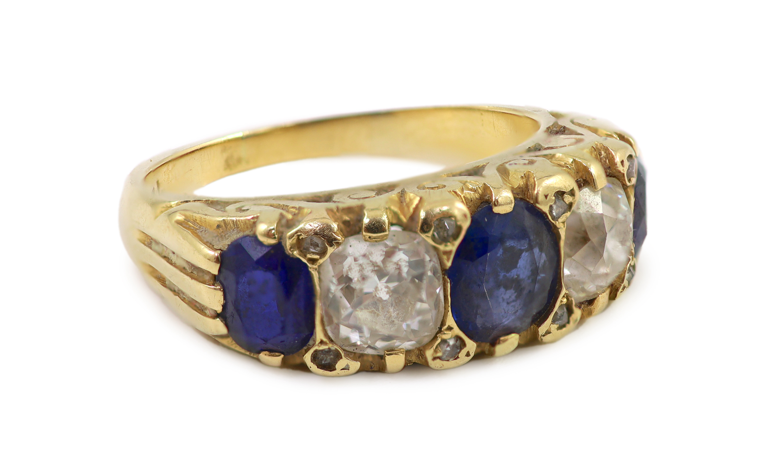 An early 20th century 18ct gold, three stone sapphire and two stone diamond set half hoop ring